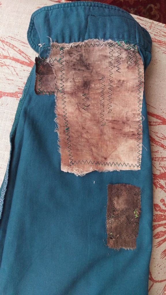 Inside view of a green short sleeve with eucalyptus printed fabrics stitched on as patches with machine zigzag.